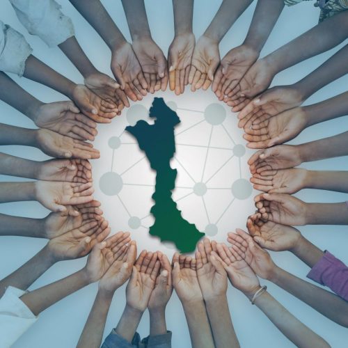 A unique image of a large group of children of East African descent showing their hands in a circular pattern. This could be as interpreted as in need of help, or asking for assistance.